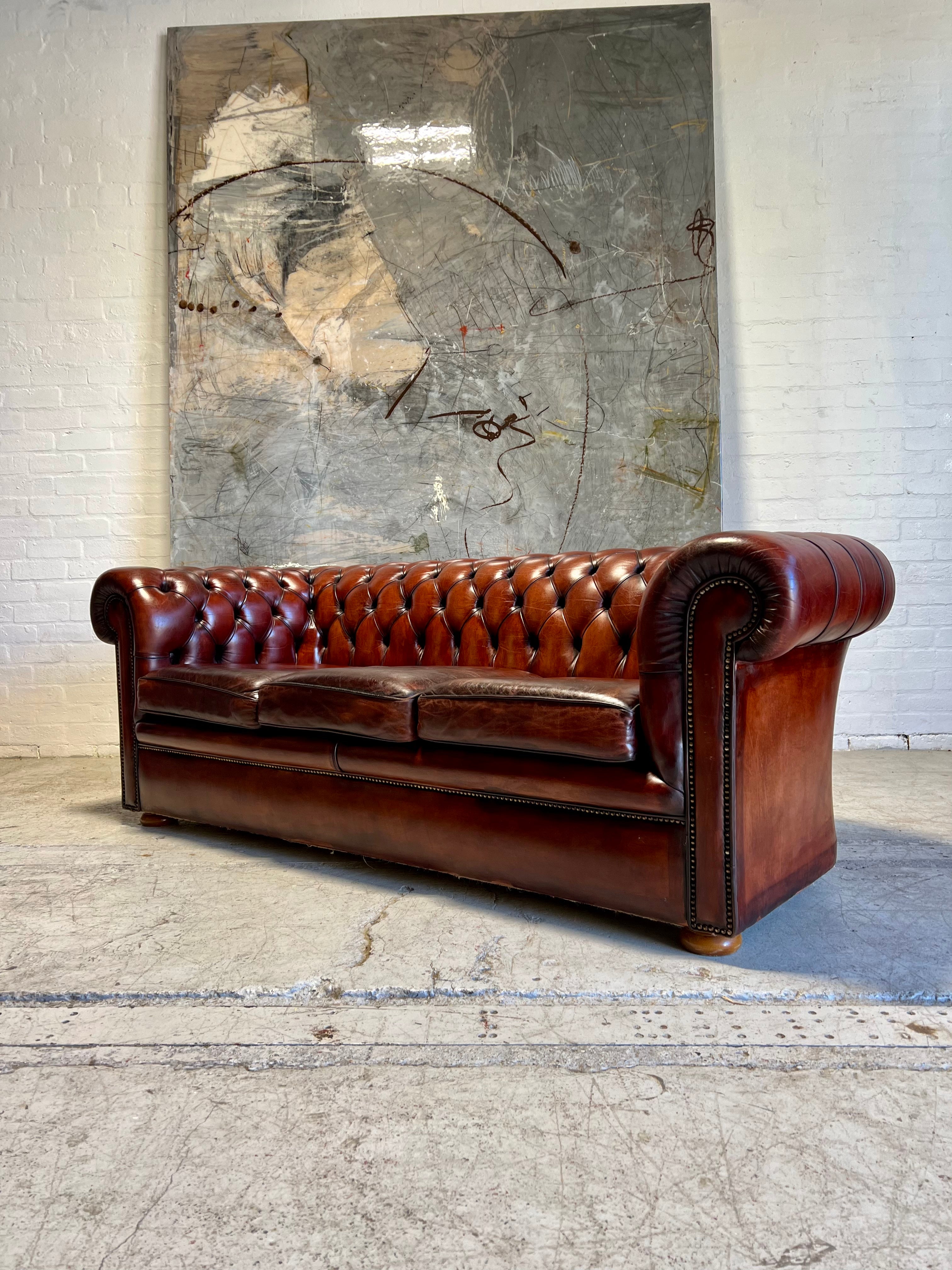 An Amazing Matching Pair of MidC Hand Dyed Leather Chesterfield Sofas Finished in A Cognac Wine