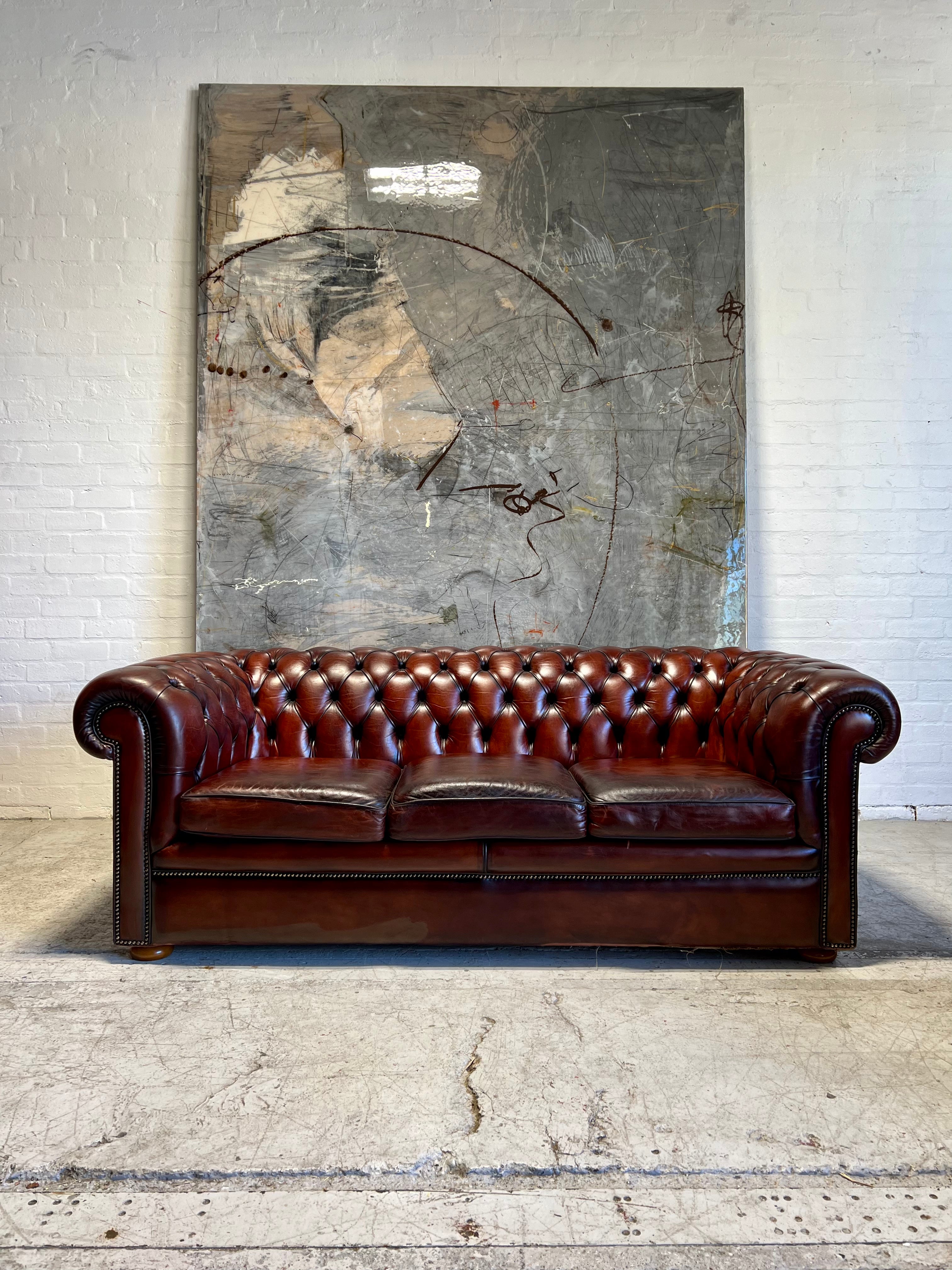 An Amazing Matching Pair of MidC Hand Dyed Leather Chesterfield Sofas Finished in A Cognac Wine