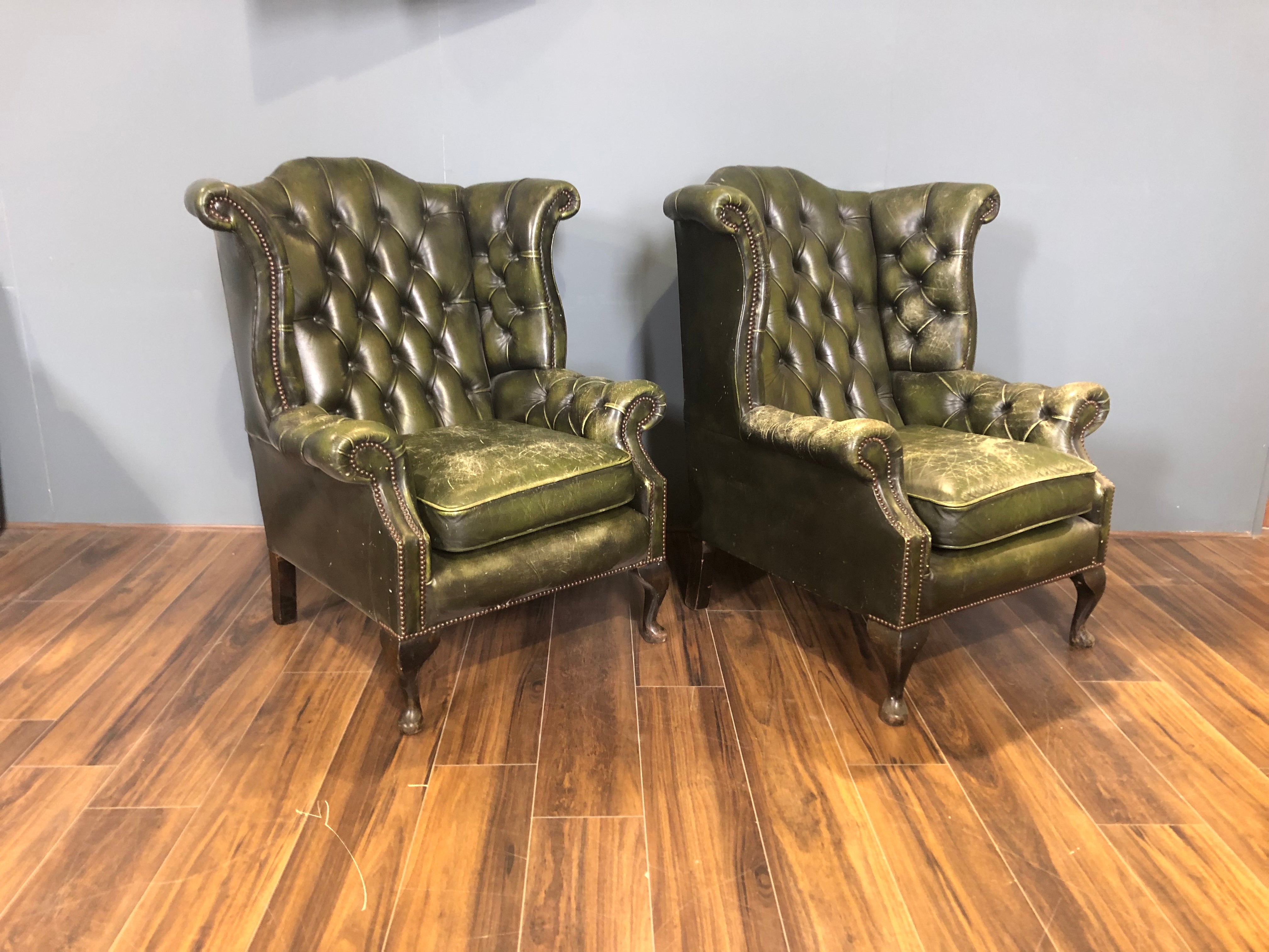 A Character-full Matching Pair of Rich Green Wing Back Chesterfield Chairs