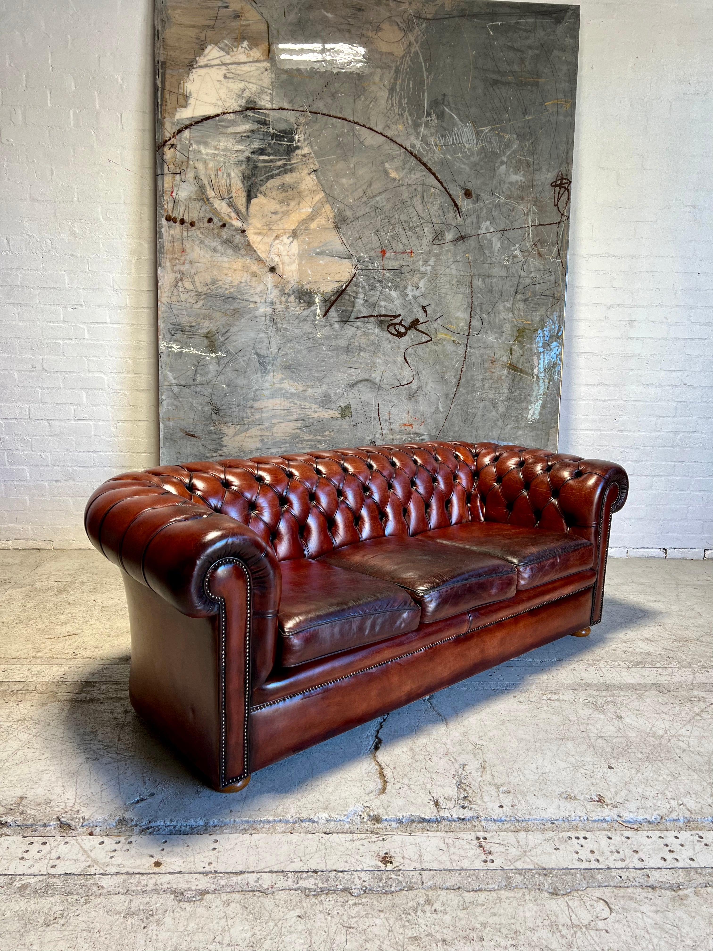 An Amazing Matching Pair of MidC Hand Dyed Leather Chesterfield Sofas Finished in A Cognac Wine