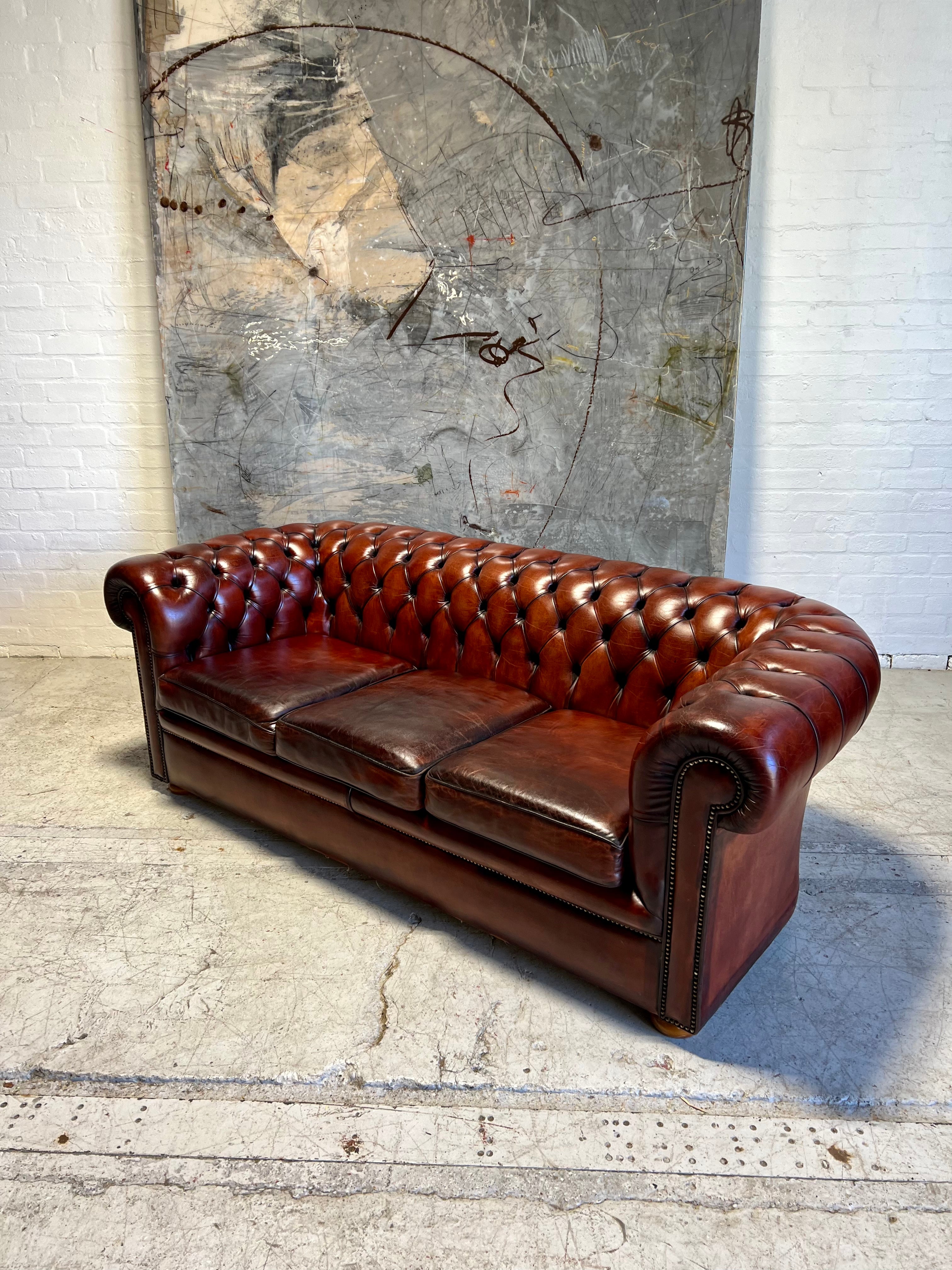 An Amazing Matching Pair of MidC Hand Dyed Leather Chesterfield Sofas Finished in A Cognac Wine