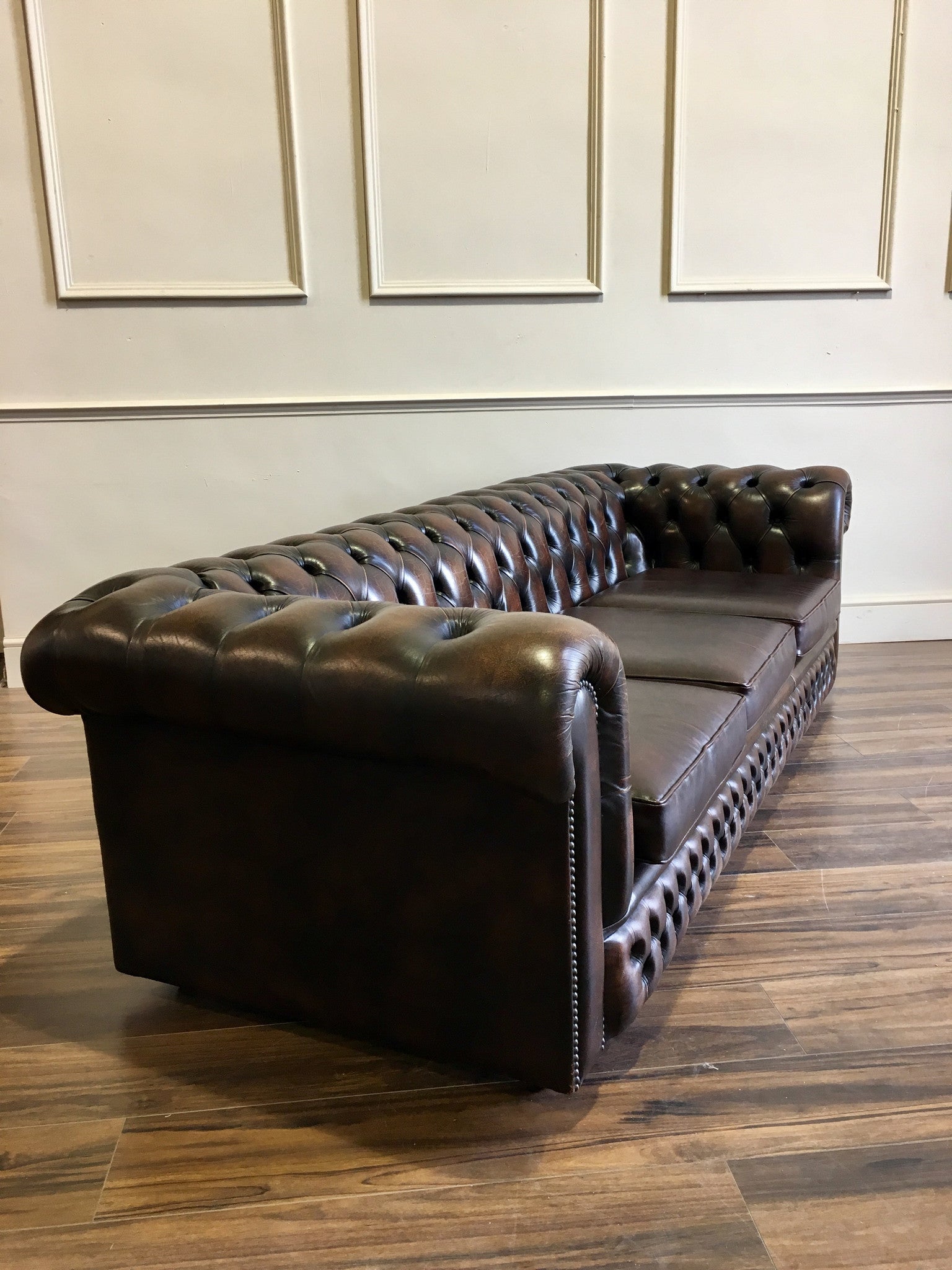 Arm of dark brown leather Chesterfield Sofa